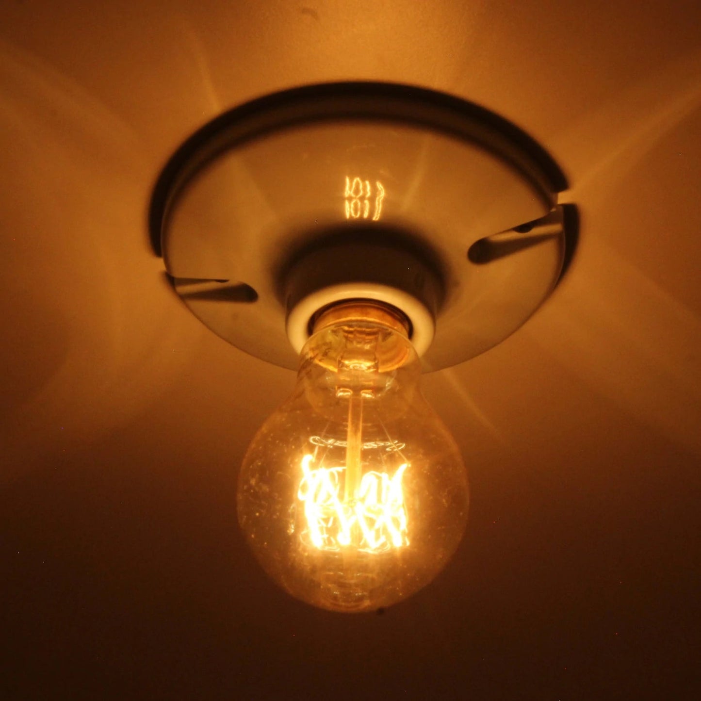 Lámpara vintage incandescente 40W globo, filamento decorativo estilo Edison, emite luz cálida ambarina.
