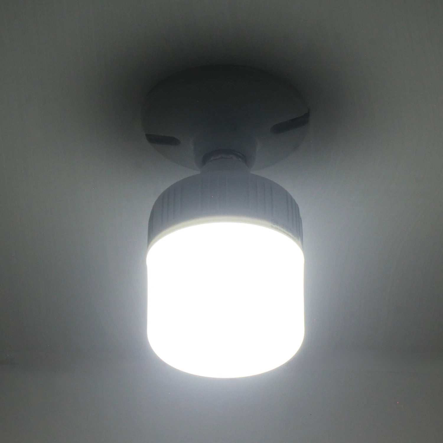 Lámpara LED blanca de 12W tipo bulbo encendida, ideal para iluminación de emergencia y uso recargable.