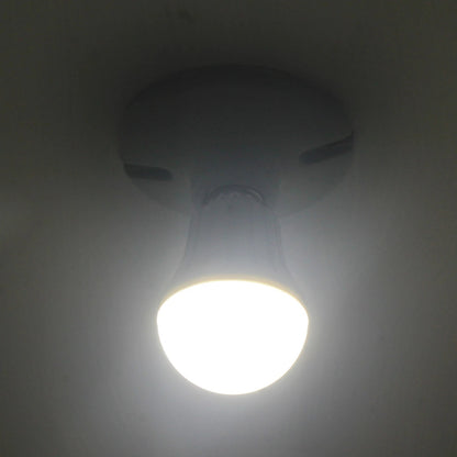 Foco LED tipo bulbo blanco, encendido y emitiendo luz brillante en un plafón de techo.