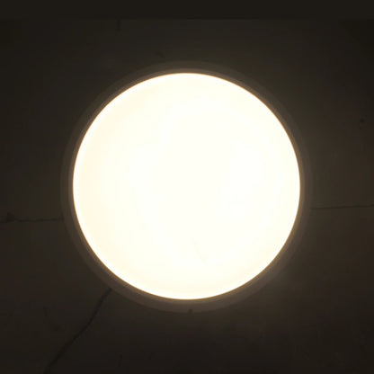 Lámpara panel LED redonda de sobreponer con luz blanca cálida encendida, ideal para techo