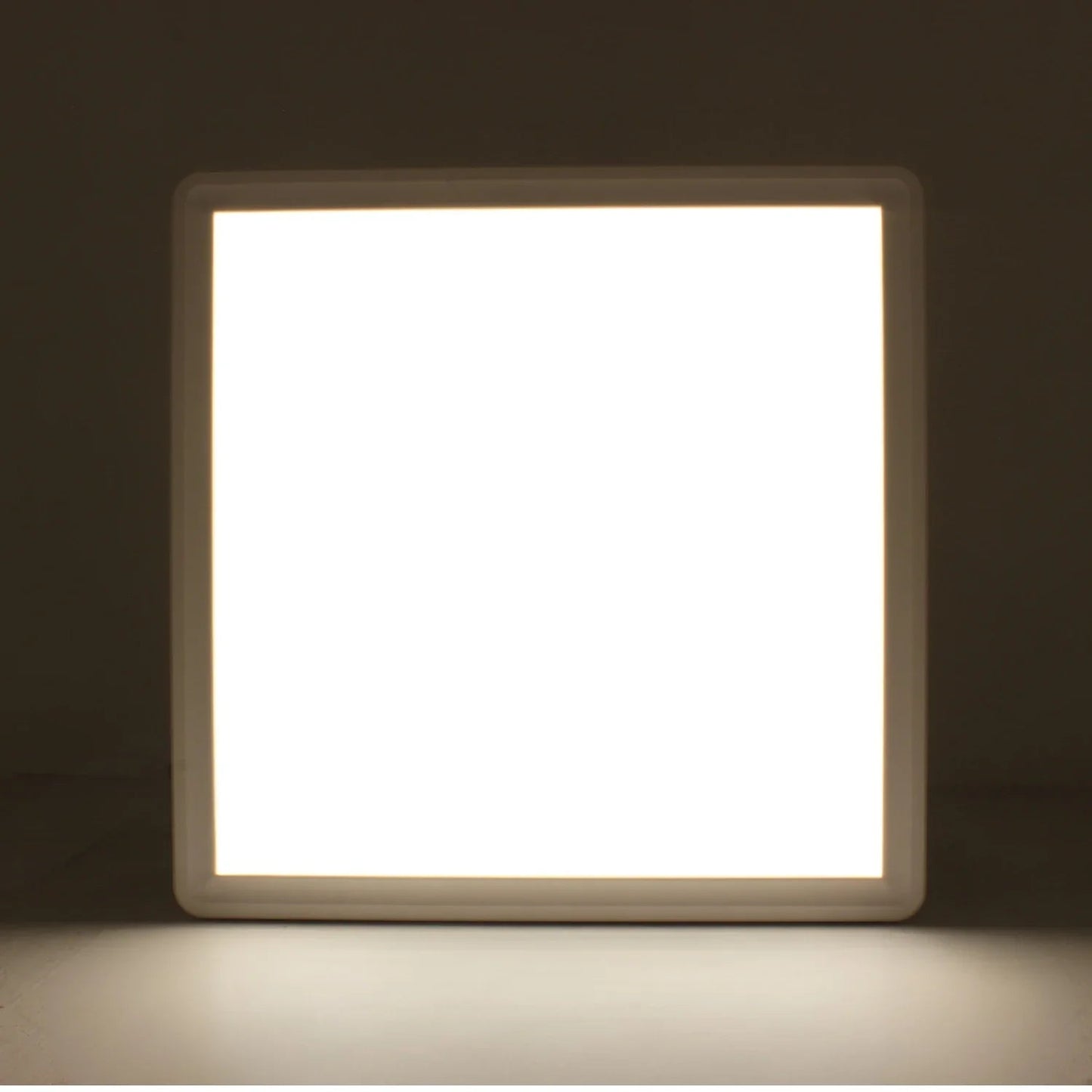 Lámpara panel LED cuadrada de luz cálida encendida, perfecta para iluminación de sobreponer
