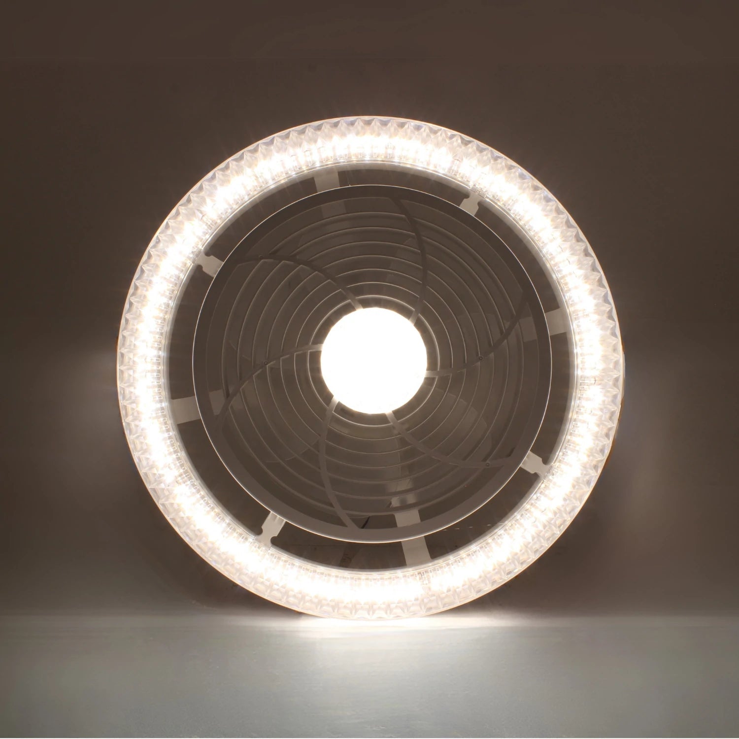 Ventilador de techo moderno con luz LED circular y central brillante, diseño integrado para iluminación y ventilación en el hogar.