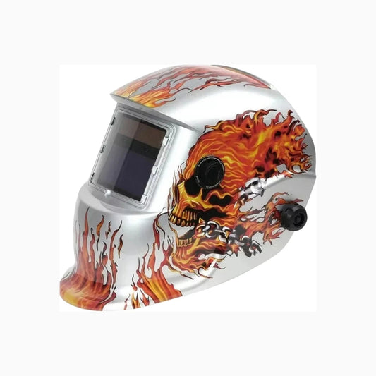 Careta de soldar automática plateada con diseño de calavera en llamas naranjas y rojas, protección ocular.