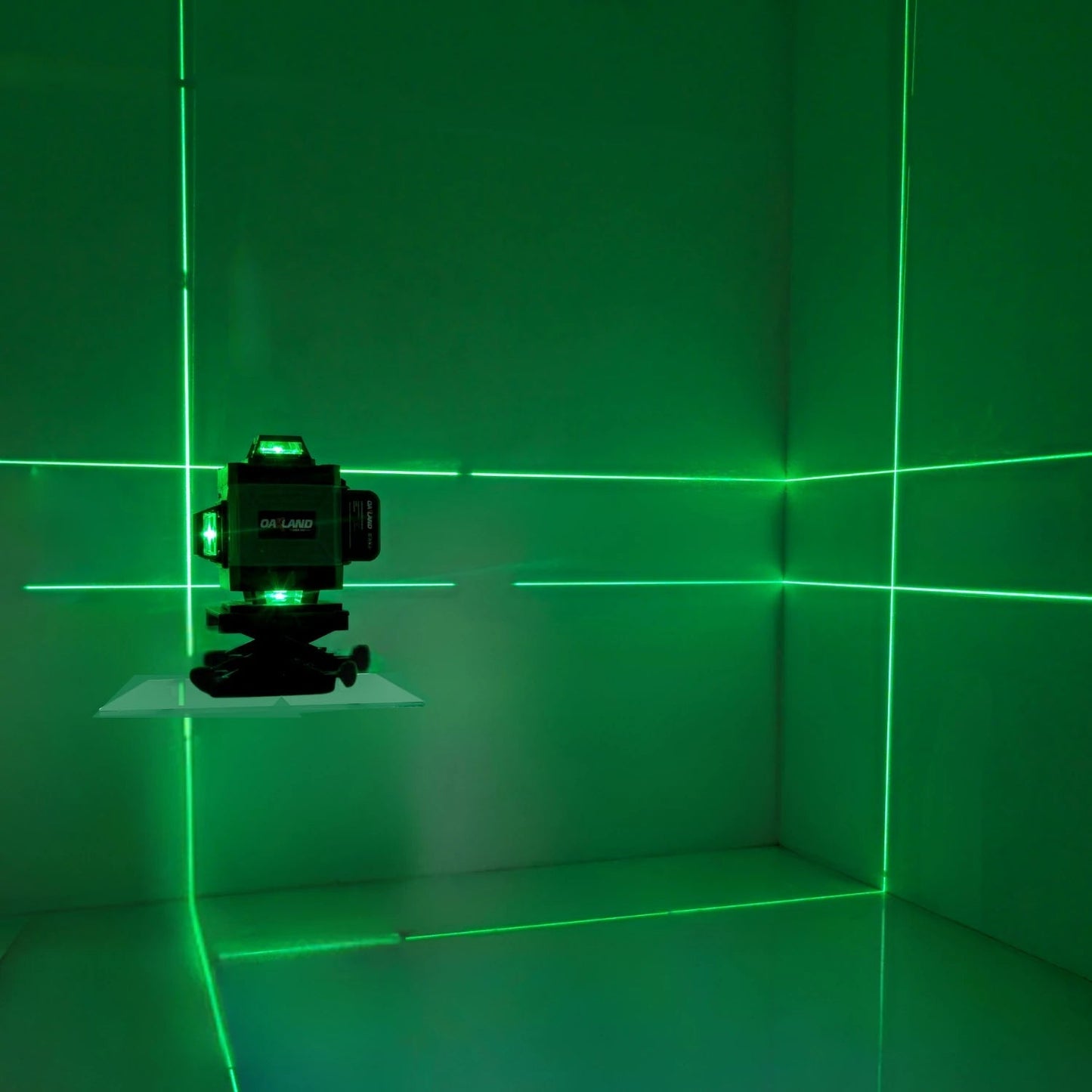 Nivel láser verde recargable OA LAND, proyectando líneas horizontales y verticales para nivelación precisa en construcción.