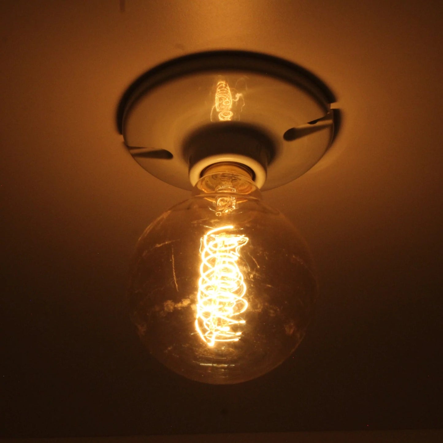 Lámpara vintage incandescente globo 35W con filamento espiral estilo Edison, luz cálida para ambiente.